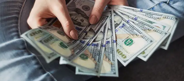 Investor holding cash highlighting Fujairah Free Zone financial advantages.